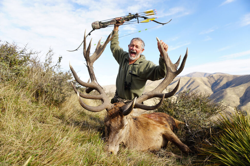 Man hunting for red stag with a bow